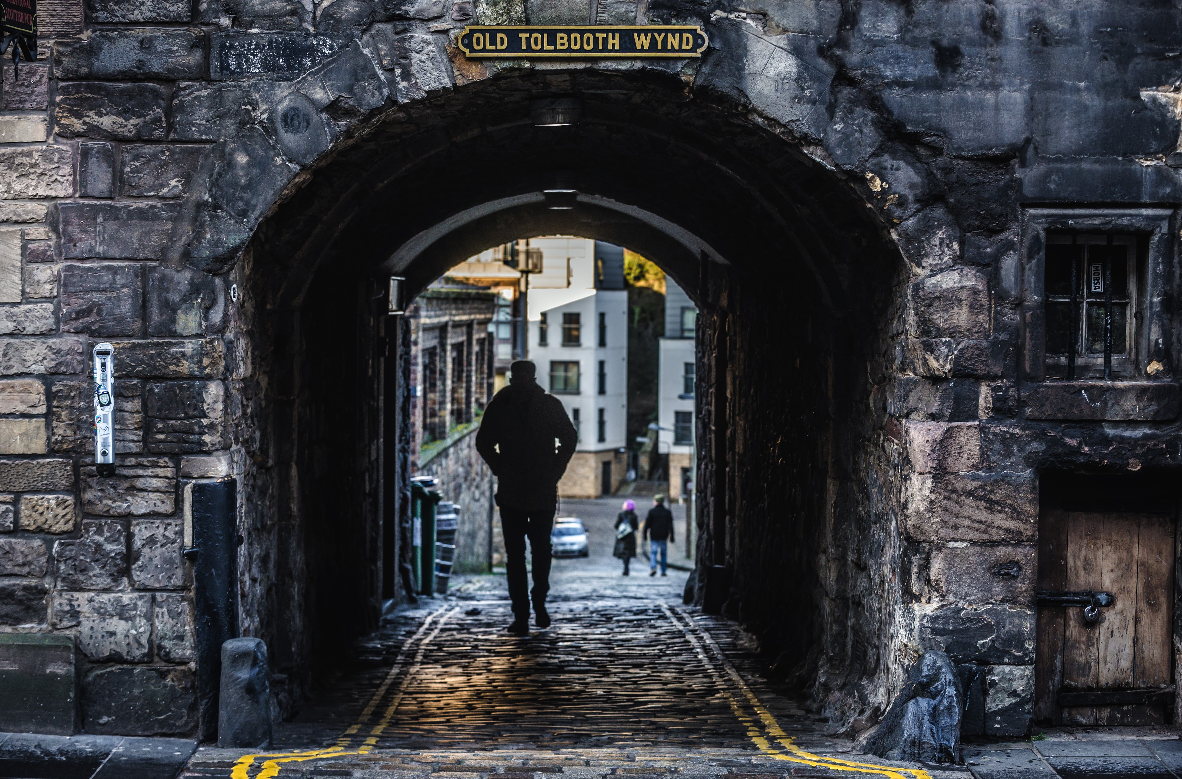 Old Tolbooth Wynd in Edinburgh seen through a dark stone arch